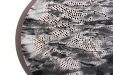 A black and white pigment print of rough water is perforated with a hot pink geometric design in this tondo by Ryan Van Der Hout. Image 3