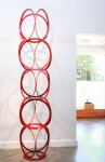 Slender rings of flattened candy red steel are stacked into an elegant yet playful column by master sculptor Shayne Dark. Image 9