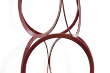 Slender rings of flattened candy red steel are stacked into an elegant yet playful column by master sculptor Shayne Dark. Image 8
