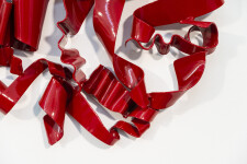 In a gorgeous candy coloured red, ribbons of steel swirl together curling and overlapping to form a circle. Image 7