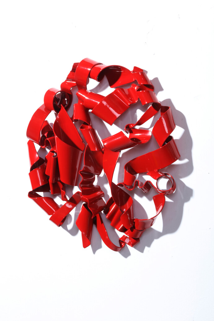 In a gorgeous candy coloured red, ribbons of steel swirl together curling and overlapping to form a circle.