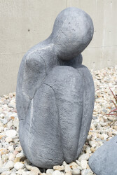 This figurative minimalist outdoor sculpture is made of concrete.