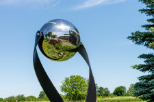 This contemporary outdoor minimalist steel sculpture features a globe. Image 7
