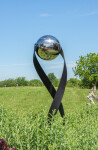 This contemporary outdoor minimalist steel sculpture features a globe. Image 2