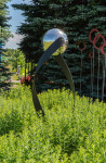 This contemporary outdoor minimalist steel sculpture features a globe. Image 3