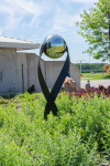 This contemporary outdoor minimalist steel sculpture features a globe. Image 4