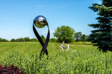 This contemporary outdoor minimalist steel sculpture features a globe. Image 10