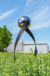 This contemporary outdoor minimalist steel sculpture features a globe. Image 5