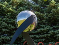 This contemporary outdoor minimalist steel sculpture features a globe. Image 8
